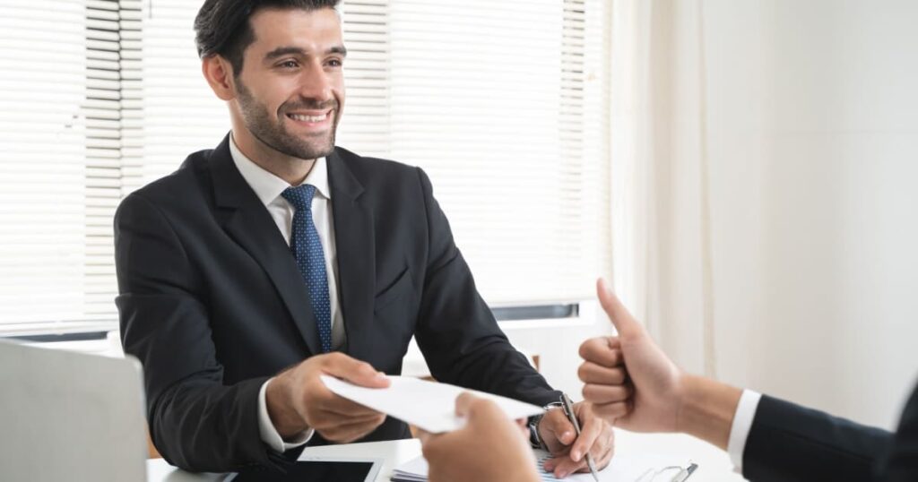 homme en costard qui donne un écochèque à un autre homme 